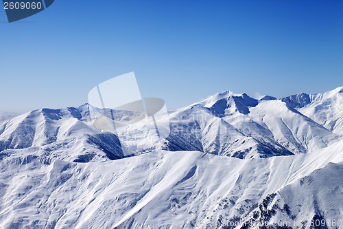 Image of Snowy winter mountains and blue sky, view from ski slope