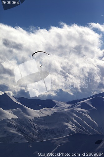 Image of Winter mountain with clouds and silhouette of parachutist