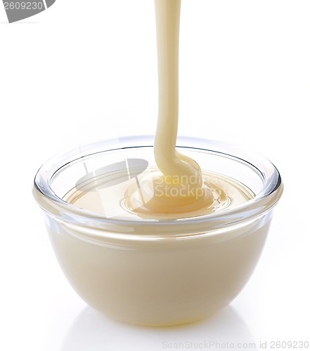 Image of pouring condensed milk with sugar in a bowl
