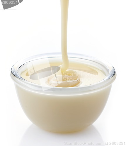 Image of pouring condensed milk with sugar in a bowl