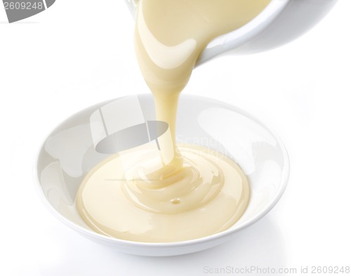 Image of pouring condensed milk with sugar in a bowl