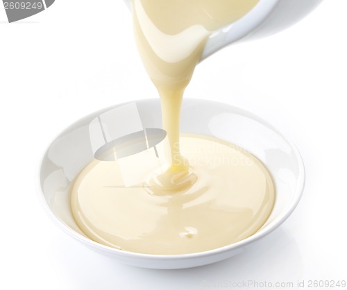 Image of pouring condensed milk with sugar in a bowl