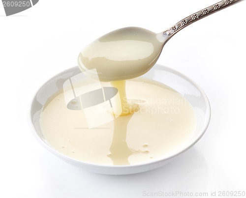 Image of pouring condensed milk with sugar in a bowl