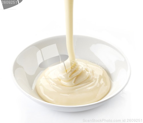 Image of pouring condensed milk with sugar in a bowl