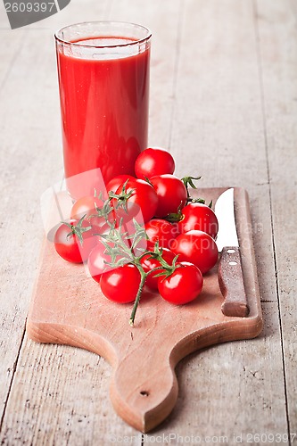 Image of tomato juice in glass and fresh tomatoes 