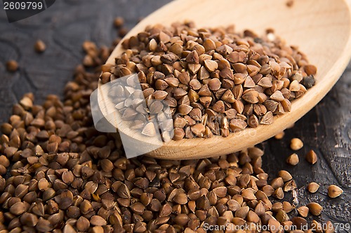 Image of Buckwheat seeds on wooden spoon in closeup 
