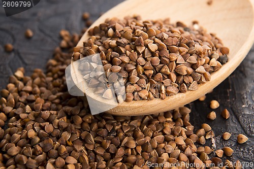 Image of Buckwheat seeds on wooden spoon in closeup 