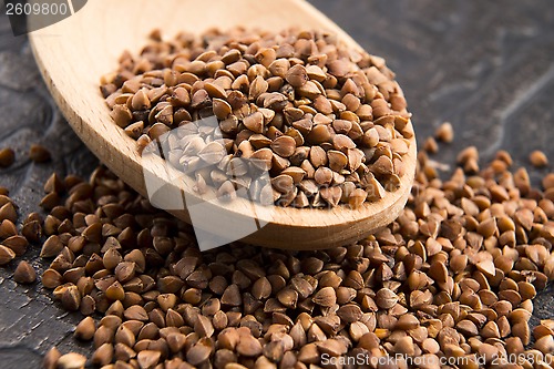 Image of Buckwheat seeds on wooden spoon in closeup 