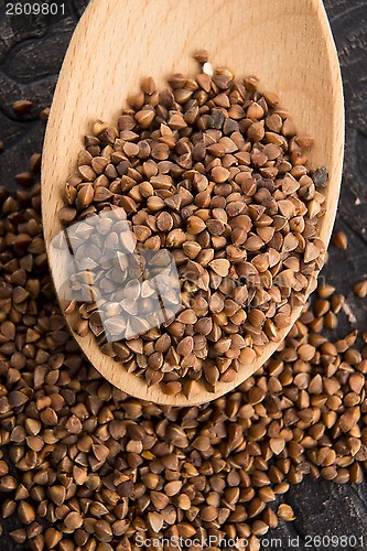 Image of Buckwheat seeds on wooden spoon in closeup 