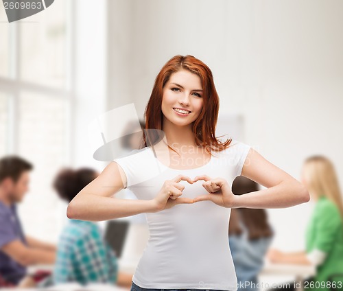 Image of smiling girl showing heart with hands