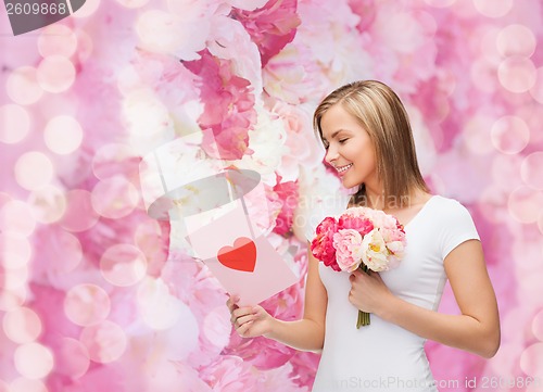 Image of smiling girl with postcard and bouquet of flowers