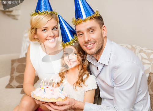 Image of smiling family in blue hats with cake