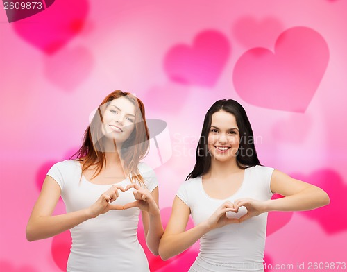 Image of two smiling girls showing heart with hands