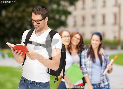 Image of travelling student with backpack and book