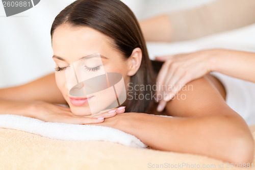 Image of beautiful woman in spa salon getting massage