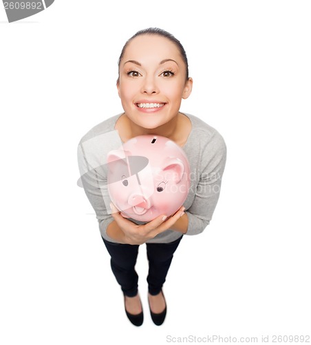 Image of happy woman with piggy bank