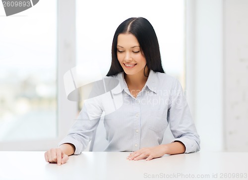 Image of smiling woman pointing to something imaginary