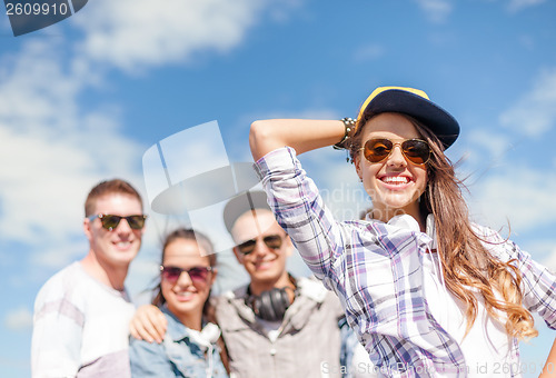 Image of teenage girl with headphones and friends outside