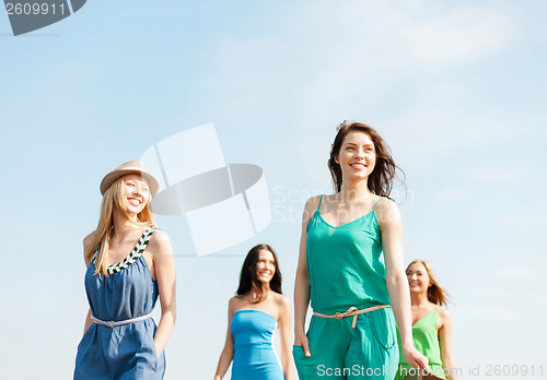 Image of smiling girls walking on the beach