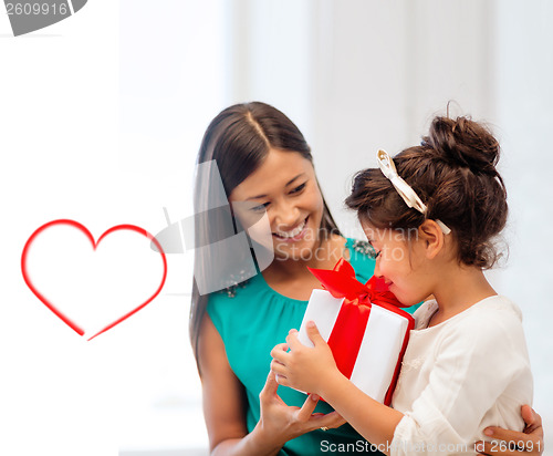 Image of happy mother and child girl with gift box