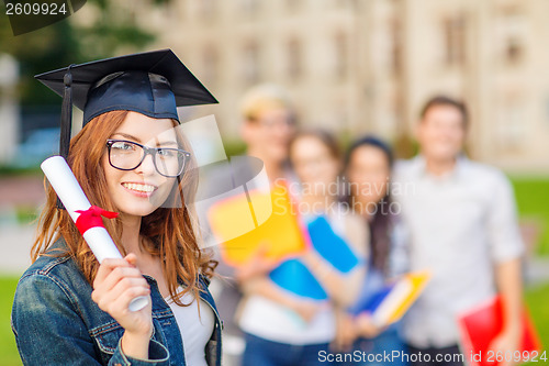 Image of smiling teenage girl in corner-cap with diploma