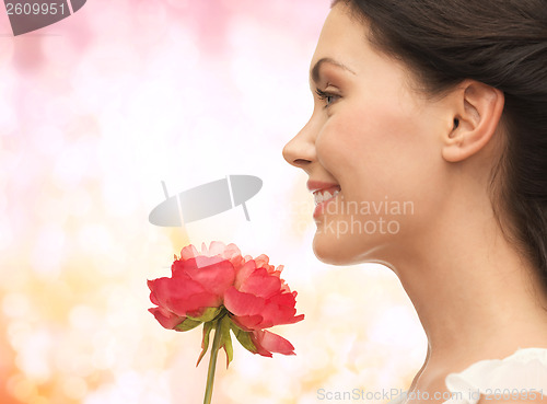 Image of smiling woman smelling flower