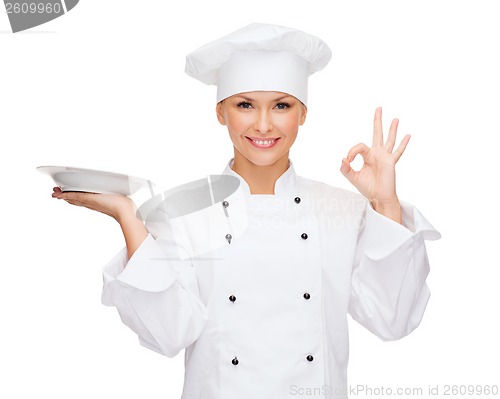 Image of female chef with empty plate showing ok sign