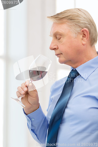 Image of older man smelling red wine