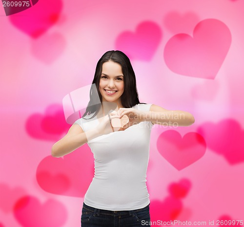 Image of smiling girl showing heart with hands