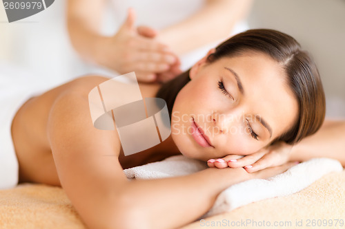 Image of beautiful woman in spa salon getting massage