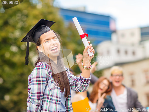 Image of smiling teenage girl in corner-cap with diploma