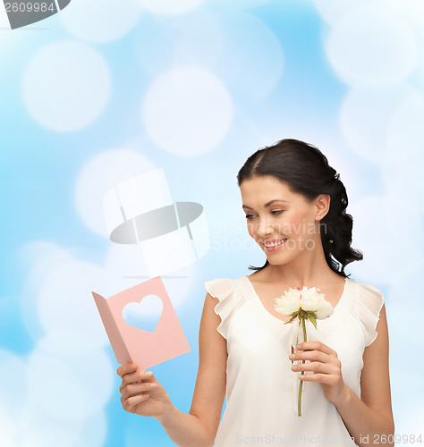 Image of young woman holding flower and postcard