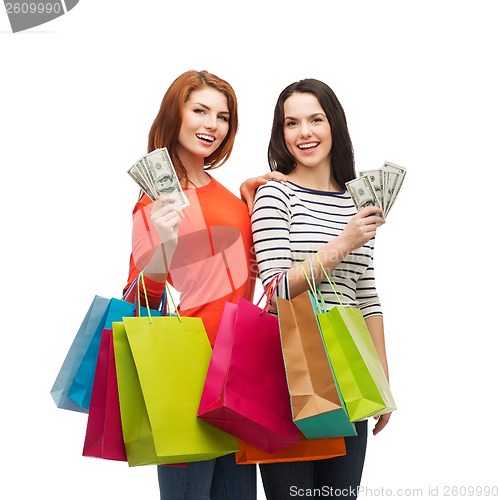 Image of smiling teenage girls with shopping bags and money