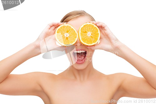 Image of amazed young woman with orange slices