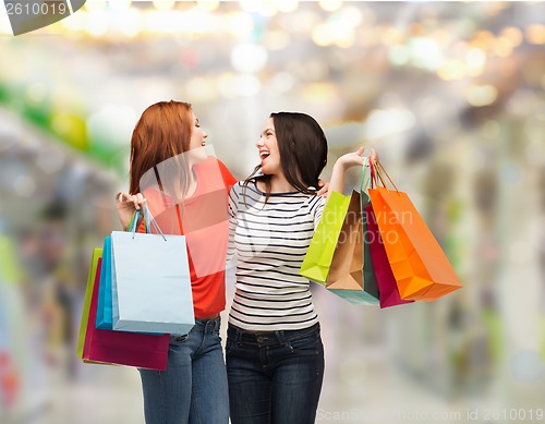 Image of two smiling teenage girls with shopping bags