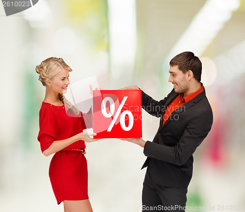 Image of smiling woman and man with red percent sale sign