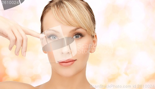 Image of beautiful woman touching her eye area