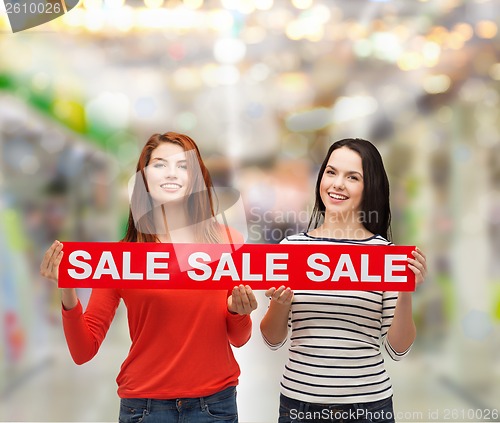 Image of two smiling teenage girl with percent sign on box