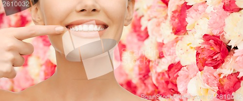 Image of beautiful woman pointing to teeth