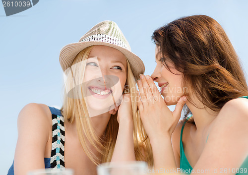 Image of girls gossiping in cafe on the beach