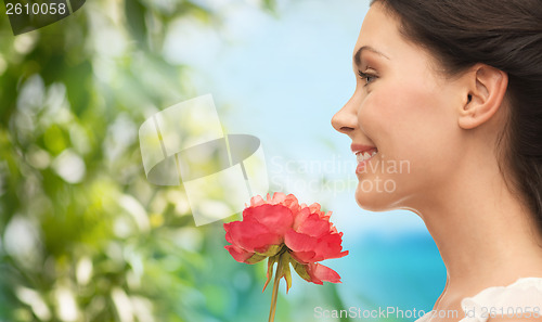 Image of smiling woman smelling flower