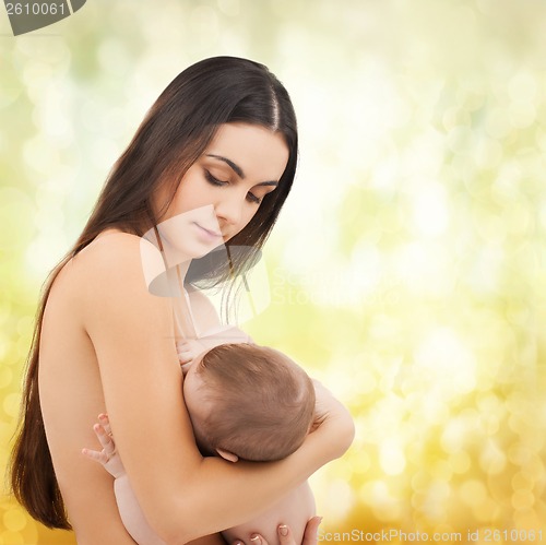 Image of happy mother feeding her adorable baby