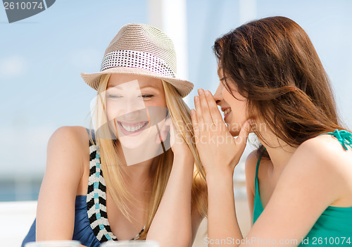 Image of girls gossiping in cafe on the beach