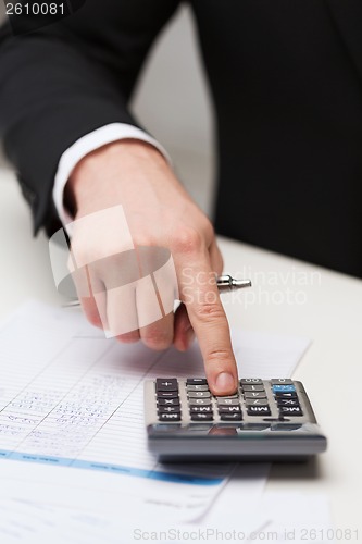 Image of close up of businessman with papers and calculator