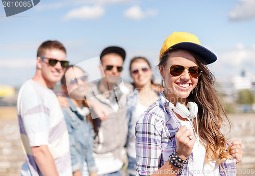 Image of teenage girl with headphones and friends outside