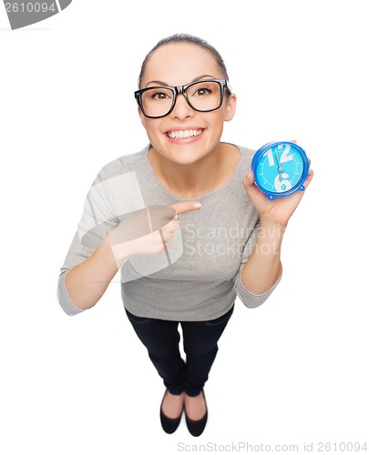 Image of woman in eyeglasses pointing finger to blue clock