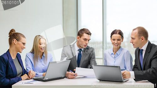 Image of business team with laptop having discussion