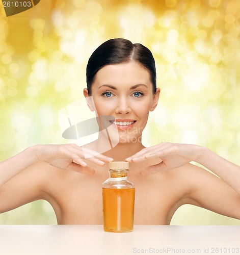 Image of beautiful woman with oil bottle