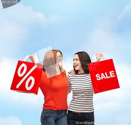 Image of two smiling teenage girl with shopping bags