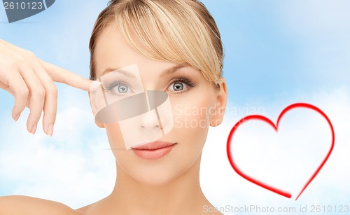 Image of beautiful woman touching her eye area